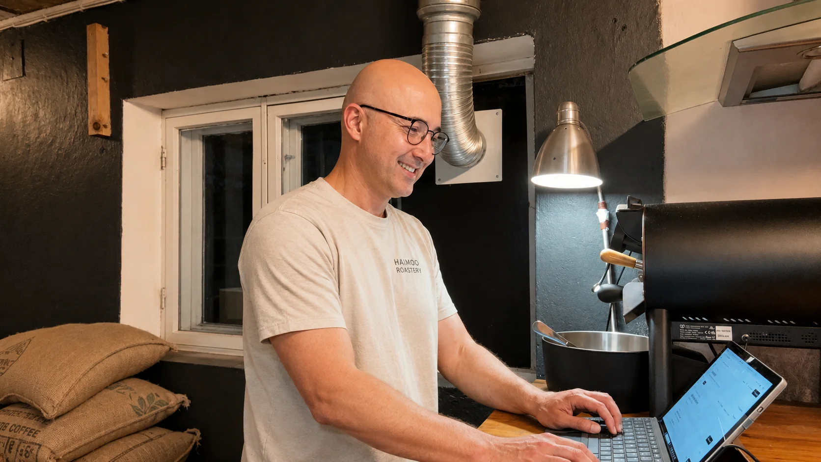 Omid työskentelee kannettavan ääressä oman yrityksensä tuotantotilassa.